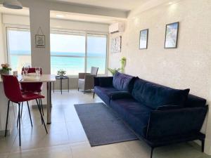 海法Seaside cozy apartment的客厅配有蓝色的沙发和桌子