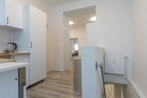 杜伊斯堡T&K Apartments - 1 to 4 Room Apartments - 20min to TradeFair Messe Airport Düsseldorf的一间铺有木地板且拥有白色墙壁的厨房