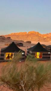 瓦迪拉姆STARDUSt CAMP的沙漠中的两顶帐篷,背景是群山