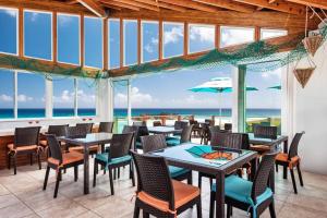 Conch BarDragon Cay Resort Mudjin Harbour的一间带桌椅的海景餐厅
