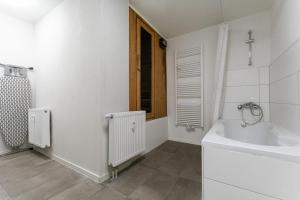 杜伊斯堡T&K Apartments - 1 to 4 Room Apartments - 20min to TradeFair Messe Airport Düsseldorf的白色的浴室设有浴缸和水槽。
