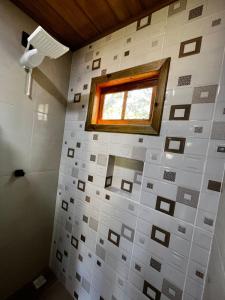 LajeadoPousada Sossego do Tocantins的浴室设有窗户和白色瓷砖墙