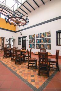 卡利圣安东尼奥精品酒店的用餐室配有桌椅,墙上挂有图片