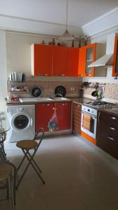 拉马萨S2 ain zaghwen nord la marsa的厨房配有橙色橱柜和洗衣机。