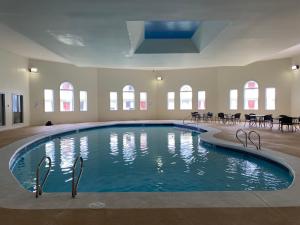 新贝德福德Whalers Inn and Suites的一个带桌椅的房间的大型游泳池