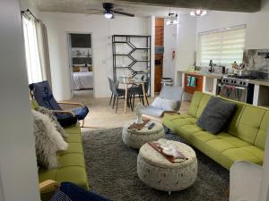 蓬塔卡纳VILLA GRANDEZZA的一间带绿色沙发的客厅和一间厨房