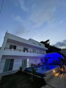 蓬塔卡纳VILLA GRANDEZZA的一座白色的大房子,晚上设有游泳池
