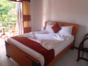 康提Vino Villa Tourists & Local Accommodations - 24 Hrs的一间卧室配有一张带白色床单的床和一扇窗户。