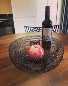拜马欧Villa Pheron - De standing - Jacuzzi 5 Personnes的一瓶葡萄酒和一张桌子上的苹果篮