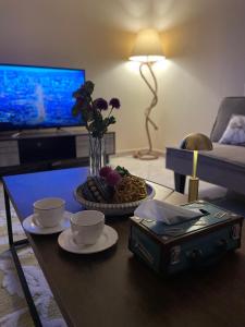 Riyadh Al Khabraاستديو عائلي بمدخل خاص ودخول ذاتي的客厅配有咖啡桌、两杯和鲜花