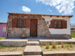 胡阿卡勒拉El Cobijo del Artista - en Huacalera的一座带木制百叶窗的小石屋