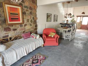 胡阿卡勒拉El Cobijo del Artista - en Huacalera的客厅设有红色椅子和石墙