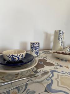 迈来亚Studio Bleu Cosy à Dar Lili Djerba的桌子上带盘子和餐具的桌子
