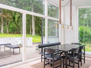 埃贝尔托夫特8 person holiday home in Ebeltoft的一间带桌椅和窗户的用餐室