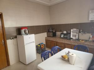 Al HachlafAppartement near airport ouled tayeb的厨房配有白色冰箱、桌子和椅子