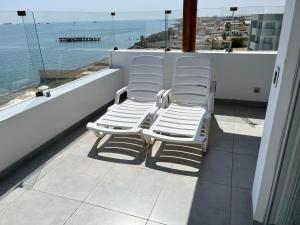 帕拉卡斯Suite 1ra Fila Vista Bahía - 100 Metros Las Velas 601 T1的两把白色椅子坐在一个眺望着大海的阳台