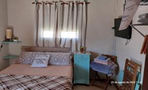 楚伊Descanso al Paso Chuy的一间卧室配有一张床、一张桌子和一个窗户。