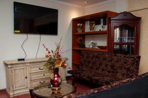 昆卡Hotel Campanario的带沙发、桌子和电视的客厅