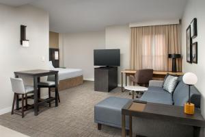 凤凰城Residence Inn by Marriott Phoenix Airport的酒店客房设有床和客厅。