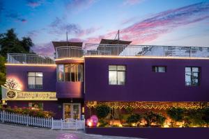 三亚夏树客栈（原船长青年旅社）的紫色的建筑,背景是日落