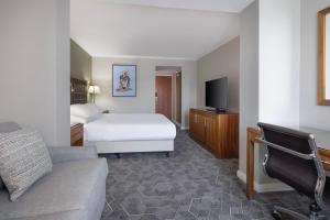 爱丁堡Delta Hotels by Marriott Edinburgh的一间酒店客房,配有一张床和一台电视