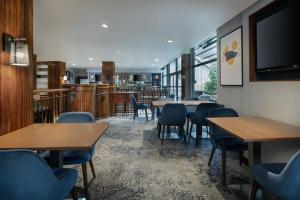 爱丁堡Delta Hotels by Marriott Edinburgh的餐厅设有桌椅和平面电视。