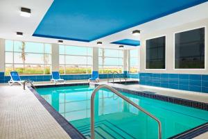 尼斯库温尼伯国际机场福朋喜来登酒店 的蓝色瓷砖和蓝色墙壁的大型游泳池