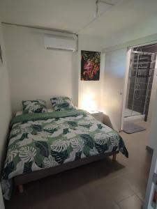 法兰西堡Appartement Clos du bois的一间卧室配有一张带绿色和白色棉被的床