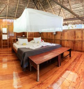马尔多纳多港Ecolucerna Lodge Tambopata的木地板客房的一张床位