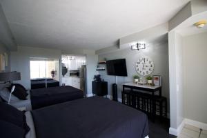 代托纳海滩Modern Beach Condo-Daytona Beach的卧室配有一张床,墙上挂着一个钟