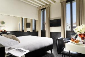 威尼斯Hotel L'Orologio - WTB Hotels的酒店客房配有一张床和一张桌子以及一张桌子。