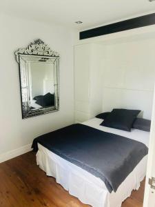 悉尼Woollahra house beautiful 3 bedroom terrace的卧室配有一张壁挂镜子的床
