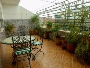 丹吉尔Appartement de standing calme en centre ville IMAZUR的天井配有桌椅和盆栽植物