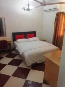 马斯喀特Sun City Hotel的一间卧室配有一张床,铺有一个 ⁇ 板地板