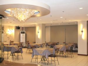 马尼拉Rosas Garden Hotel的一间带桌椅和吊灯的用餐室
