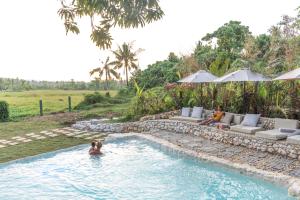 卢纳将军城The Hillside Resort Siargao的夫妇在度假村的游泳池里