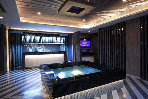 富山ホテルウォーターゲート富山 レジャーホテル 大人用ホテル的客房设有热水浴缸和电视。