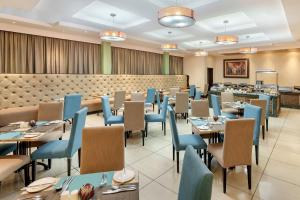 卢萨卡卢萨卡普罗蒂亚酒店的一间配备有桌子和蓝色椅子的用餐室