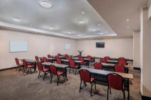 卢萨卡卢萨卡普罗蒂亚酒店的一间会议室,配有桌椅和屏幕