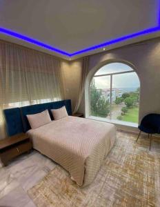 丹吉尔luxury condo with sea view的一间卧室设有一张大床和拱形窗户