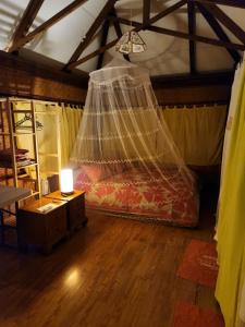 普纳奥亚Fare Cocoon的一间卧室配有一张带蚊帐的床