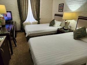 塔什干HL 309 Hotel的酒店客房设有两张床和电视。