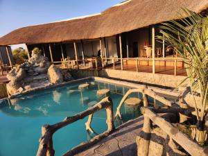 MababeMababe River Lodge & Campsite的一座带游泳池的度假村,位于一座建筑前