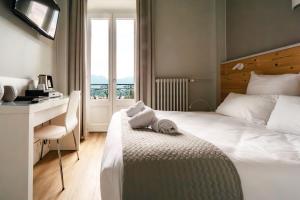 艾克斯莱班Hôtel Gallia的配有一张床、一张书桌和一扇窗户的酒店客房