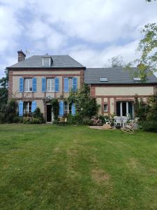 埃屈埃莫维尔La mare aux petits diables的一间设有蓝色窗户和庭院的大型砖屋