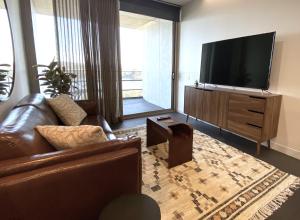 堪培拉Stylish Central Lake View Apartment的带沙发和平面电视的客厅