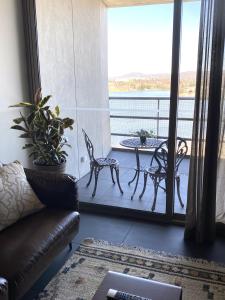 堪培拉Stylish Central Lake View Apartment的客厅配有沙发和阳台桌子