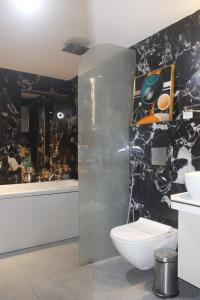 丹巴德LUXUS INN的一间带卫生间和黑色墙壁的浴室