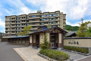 JozankeiJozankei Onsen Yurakusoan的停车场前方的大型公寓楼