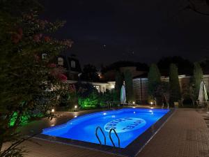塔什干HL 309 Hotel的夜间大型蓝色游泳池
